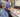 Two people working at a printing press with printed materials on a table.