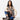 A women with dark hair sitting on the ground with jeans and a eco printed vest.