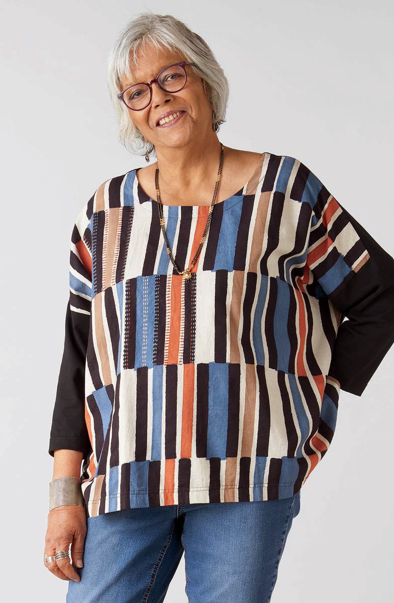 Woman wearing a colorful striped sweater against a white background