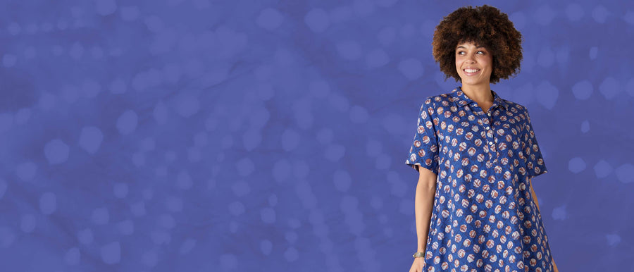 Woman wearing a blue patterned dress against a blue background