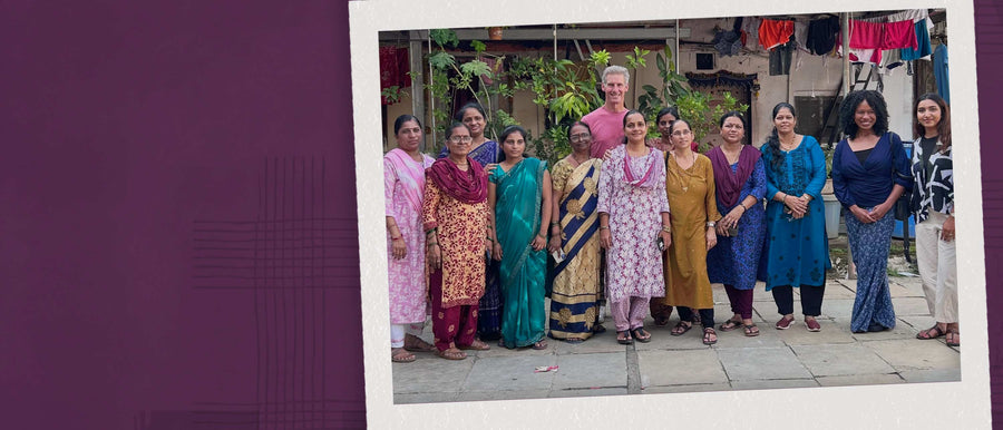 A group of women artisans along with Kai Ryssdal in Mumbai in a Polaroid with a purple background 